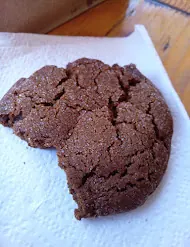A ginger molasses cookie with a cracked top, one bite taken
